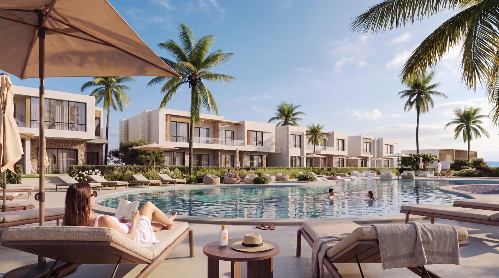 NAVAIA's residences round a large pool, palms between them, a guest reading on a lounger in the foreground